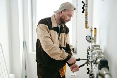Technicus voert onderhoud uit aan de leidingen van een installatie