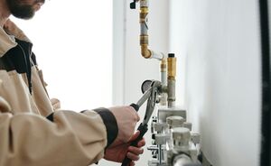 Technicus monteert de leidingen van een warmtepompinstallatie